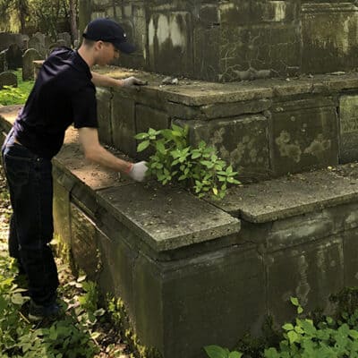 Cadet cleaning a tombstone in the Oswiecim Jewish cemetery